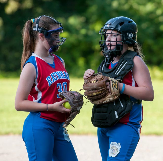 Ashley Alberghini, left, and Emily Mortimer of the Raynham Rage 12U girls all-star softball team talk strategy during a game. The Rage went 13-4 this season.

 Photo by K.A. MacDonald