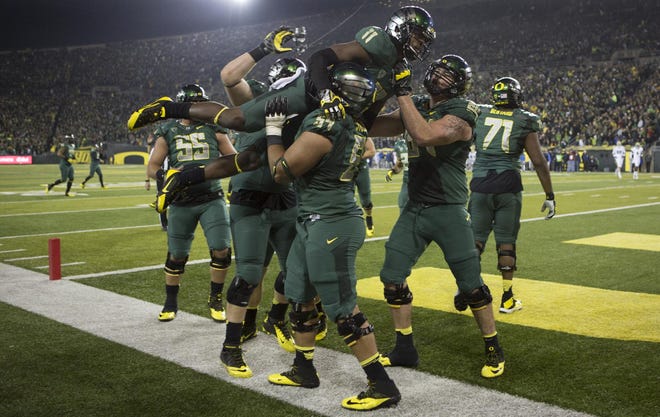 Oregon’s Bralon Addison, held high by his teammates after scoring against UCLA last fall at Autzen Stadium, is optimistic he’ll be able to play this season after ACL surgery in April. (Carl Davaz/The Register-Guard)