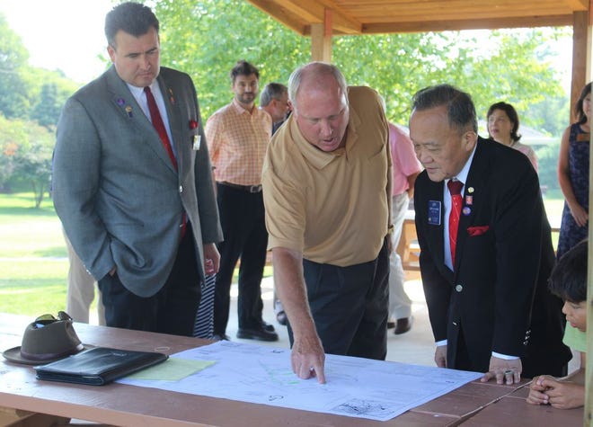 Past Rotary Club President Jim Rock shows Rotary International President Gary C.K. Huang and District Gov. Jason Piatt the plan of Rotary Park. Rock oversaw the project which was done by Waynesboro Rotarians in honor of Rotary International’s centennial in 2005.