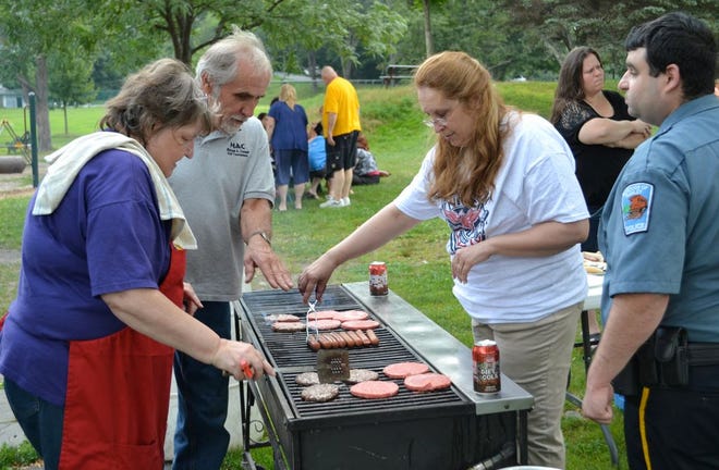 HAWLEY- From left: Hawley Borough Secretary Leah Peoples, Palmyra Township Supervisor and Road Master Joe Kmetz, Mary Sanders from Hawley Borough Council and Hawley Borough Police Officer Mike Jaferis were busy preparing hot dog and hamburgers in Bingham Park Tuesday night, for National Night Out. The event is aimed to help people stand against crime in their communities. Hawley Borough police and other officials were in attendance as well as area residents to talk about peoples' concerns. 
News Eagle photo by Katie Collins