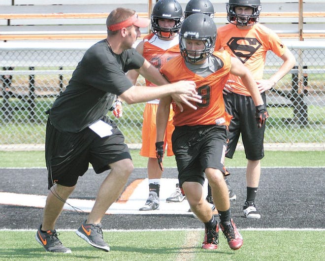 Massillon receiver Dylan Henderson works with assistant coach Cale Miller during a recent practice. Henderson, a senior, will get his first chance at a big role in the Tigers’ offense this season.