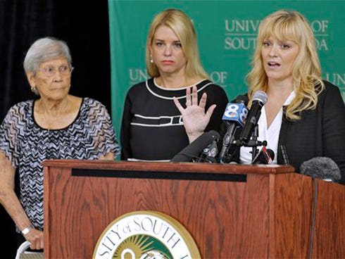 University of South Florida Associate Professor Erin Kimmerle, right, gestures as she stands with Florida Attorney General Pam Bondi, center, and Ovell Krell during a news conference Thursday at the University of South Florida in Tampa, regarding the unmarked graves found at the former Arthur G. Dozier School for Boys in Marianna. University researchers have positively identified the remains of George Owen Smith, through a DNA match with his sister Ovell Krell, as one of the first to be exhumed from the 55 unmarked graves. Smith was 14 when he disappeared from the school in 1940.