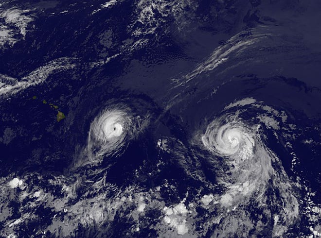 This image provided by NOAA taken Thursday Aug. 7, 2014 at 2 a.m. EDT shows Hurricane Iselle, left and Hurricane Julio. The center of Hurricane Iselle is expected to pass very near or over Hawaii's Big Island Thursday night and just south of the smaller islands Friday.
