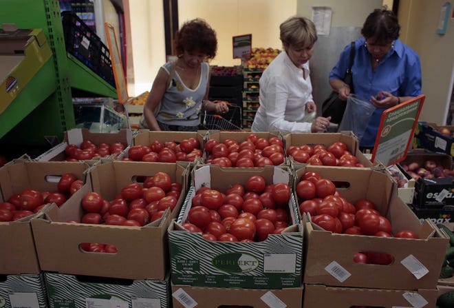 Women choose Dutch tomatoes at a supermarket in downtown Moscow on Thursday, Aug. 7, 2014. The Russian government has banned all imports of meat, fish, milk and milk products and fruit and vegetables from the United States, the European Union, Australia, Canada and Norway, Prime Minister Dmitry Medvedev announced Thursday.