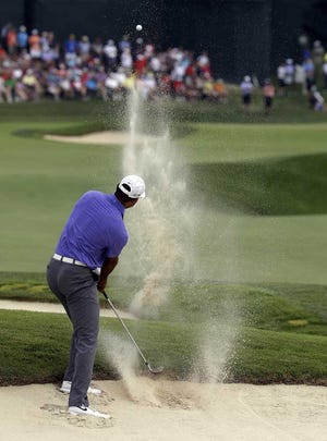 Tiger Woods hits out of the bunker on the 18th hole during the first round of the PGA Championship golf tournament at Valhalla Golf Club on Thursday, Aug. 7, 2014, in Louisville, Ky. (AP Photo/John Locher)