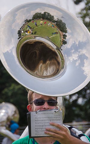 Ryan Hughes plays the sousaphone while practicing with the Asheboro High School Marching Band 8.7.14. The band has been practicing all week from 10-8pm. 
 Ryan Hughes plays the sousaphone while practicing with the Asheboro High School Marching Band 8.7.14. The band has been practicing all week from 10-8pm. 
 Carmen Vazquez seeks shelter from the hot sun beneath her color gurad flag during a break in Asheboro High School Marching Band practice 8.7.14. The band has been practicing all week from 10-8pm. 
 Kayla Surratt plays the cymbals while practicing with the Asheboro High School Marching Band 8.7.14. The band has been practicing all week from 10-8pm.