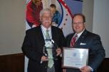 Insurance Commissioner Wayne Goodwin presents the SHIIP Coordinator of the Year Award to Jim Burke of Gaston County.