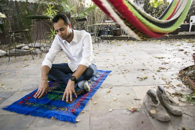 Omar Akersim, 26, is seated on his prayer rug at his home in Los Angeles. Akersim is among a growing number of American Muslims challenging the long-standing interpretations of Islam that defined their parents’ world.