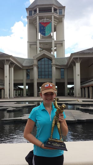 Olivia Whitten, 14, poses with her winner’s trophy at World Golf Village. The Flagler Beach teen has been golfing for only a couple of years and has already won a slew of tournaments.