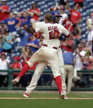 Philadelphia Phillies' Ryan Howard, back, celebrates with Cody Asche, front, after he hit a one run single against the New York Mets in the ninth inning of a baseball game Sunday, Aug. 10, 2014, in Philadelphia. The Phillies won 7-6. (AP Photo/H. Rumph Jr)