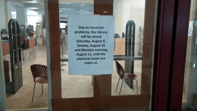 Signs posted at Mandel Public Library indicating its closure through Monday morning. (Michael Denison/ The Palm Beach Post)