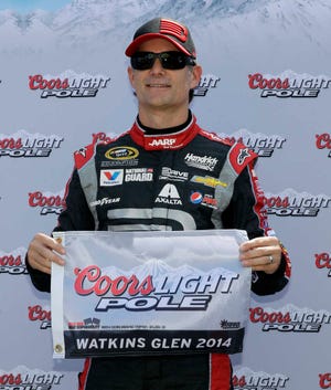 Jeff Gordon holds the pole position flag after a qualifying session for Sunday's NASCAR Sprint Cup Series auto race at Watkins Glen International, Saturday, Aug. 9, 2014, in Watkins Glen N.Y. Gordon qualified on the pole for Sunday's race. (AP Photo/Mel Evans)