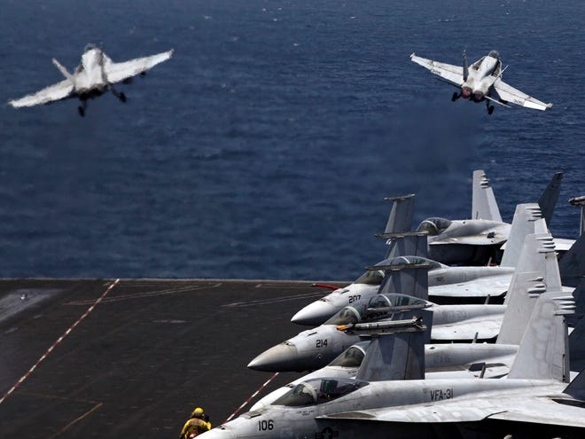 U.S. F/A-18 fighter jets take off for mission in Iraq from the flight deck of the U.S. Navy aircraft carrier USS George H.W. Bush, in the Persian Gulf, Monday.