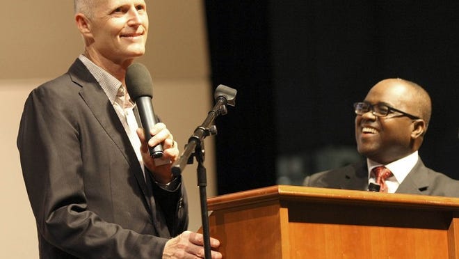 Gov. Rick Scott (left), addressing a group of Haitian evangelists along with Bishop Mathieu Jean Baptiste, who was translating the governor’s remarks at the annual Haitian Evangelist Crusade on Aug. 10, 2014, at John I. Leonard High School in Greenacres.