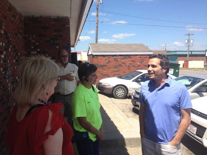 Greg Orman chats with Lavonna Lemons, in red, and the husband-and-wife pest control team of Dan and Terri Belisle outside a Topeka Mr. Goodcents restaurant. Orman started an eight-day bus tour of Kansas on Monday.