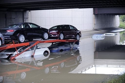 A car carrier is stranded along a flooded stretch of I-696 at the Warren, Mich. city limits Tuesday morning, Aug. 12, 2014. Warren Mayor James Fouts said roughly 1,000 vehicles had been abandoned in floodwaters in the suburb where many roads were closed after 5.2 inches of rain fell Monday. (AP Photo/Detroit News, David Coates)