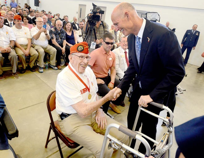 Bill Festing of Gulf Breeze shakes hands with Florida Governor Rick Scott on Tuesday at the Crestview National Guard Armory. Scott awarded a crowd of veterans with the Governor's Veterans Service Award medal.