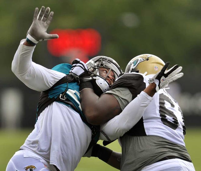 Will.Dickey@Jacksonville.com--08/04/14--Defensive end Ryan Davis (left) tries to get around center Patrick Lewis during an NFL Jaguars team training camp practice Monday, August 4, 2014 in Jacksonville, Florida. (The Florida Times-Union, Will Dickey)
