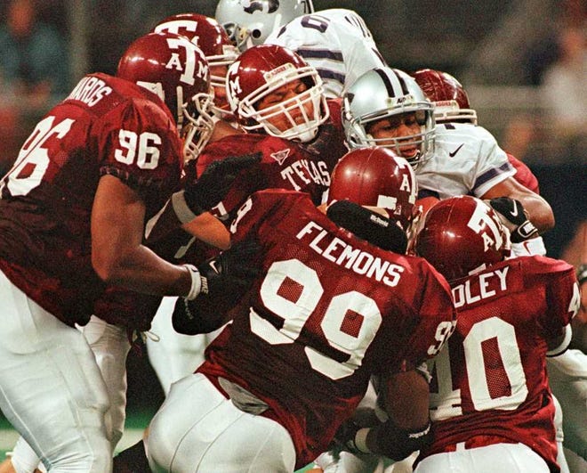 Members of the Texas A&M defense Ron Edwards (96), Ronald Flemons (99) and Roylin Bradley (40) gang tackle Kansas State Wildcats quarterback Michael Bishop, right, during the second half of the Big 12 Championship game Dec. 5, 1998, at the Trans World Dome in St. Louis.
