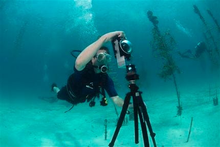 In this Aug, 9, 2014 photo provided by Catlin Seaview Survey, Mitchell Tartt, of the Office of National Marine Sanctuaries, trains to take 360-degree panoramas of the corals off the coast of Islamorada, Fla.