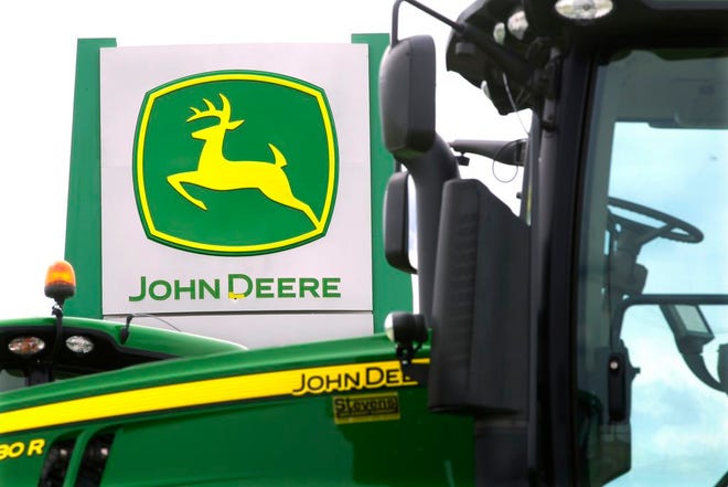 This Sunday, June 8, 2014 photo shows John Deere farming equipment at a dealership in Petersburg, Ill. Deere & Co. reports quarterly financial results before the market opens Wednesday, Aug. 13, 2014. (AP Photo/Seth Perlman)