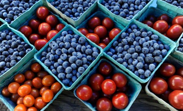 Blueberries and cherry tomatoes await customers at a Cape Cod farmers market