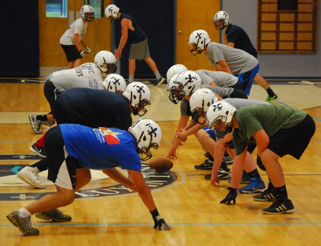 Stoico/Democrat photo

St. Thomas Aquinas football players lineup in formation during their first practice of the 2014 season on Wednesday in Dover.