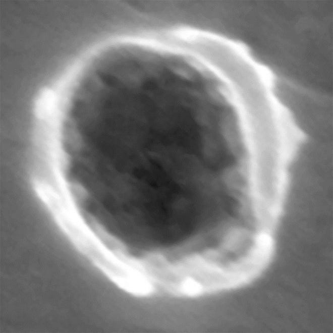 This undated image provided by the journal Science via Stardust shows the view of a dust particle impact on Al foil collector. Scientists said seven microscopic particles collected by NASA's comet-chasing spacecraft, Stardust, appear to have originated outside our solar system. The dust collectors were exposed to space in the early 2000s and returned to Earth in 2006.