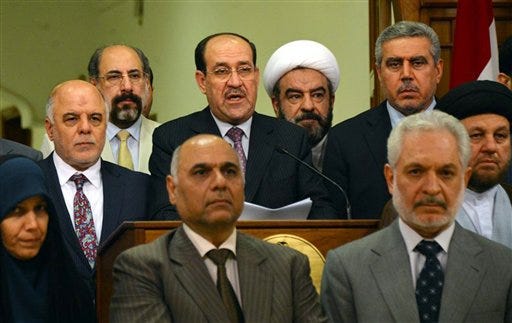 In this Thursday, Aug. 14, 2014 handout photo from the Iraqi government, Iraq's prime minister for the past eight years, Nouri al-Maliki, speaks at a podium surrounded by Iraqi lawmakers, during an address to the nation, announcing that he is stepping down in Baghdad, Iraq. Al-Maliki relinquished his post Thursday to fellow Dawa Party member Haider al-Abadi, seen at left, ending a political deadlock that has plunged the country into uncertainty as it fights a Sunni militant insurgency.(AP Photo/Iraqi Government))