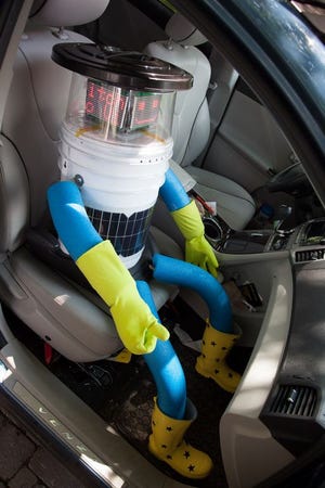 This undated photo made available by Ryerson University in Toronto on Thursday, Aug. 14, 2014 shows hitchBOT in a car. The talking robot that's been hitchhiking rides from strangers to travel from Canada's east to west coast is nearing the end of its journey. Its final destination is Victoria, British Columbia, Canada which its creators expect it to reach by Aug. 17, 2014. (AP Photo/Ryerson University)