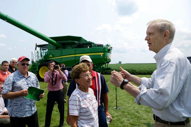 In this Thursday, July 31, 2014 photo, Republican candidate for governor Bruce Rauner talks to central Illinois farmers in Lincoln, Ill., saying a coalition from the state's agriculture industry is backing his bid to unseat Democratic Gov. Pat Quinn. Rauner, a Winnetka, Ill., businessman, says he will be a champion for agriculture, traveling the globe on his own dime to promote Illinois products and working to reduce regulatory burdens. (AP Photo/Seth Perlman)