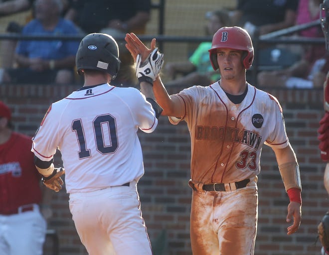 Brooklawn, NJ, first baseman Anthony Harrold, right, is congratulated by teammate Fran Kinsey after scoring during Friday's contest against Jacksonville, Fla., Harrold went four-for-four as the defending World Series champs rolled to a 9-2 triumph. (Ben Earp /Shelby Star photo)
