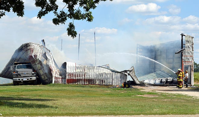 Sherwood Township firefighters put water on the remains of the Stanton Farms chemical barn Friday afternoon. DON REID PHOTO