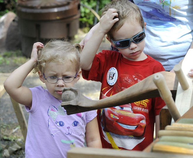 Siblings Kyra Smith, 3, and her brother, Avery, 5, Warwick, both seem a little perplexed over what the colonial woodworker is making at the Moland House in Warwick during their annual reenactment to celebrate George Washington's August 1777 encampment there