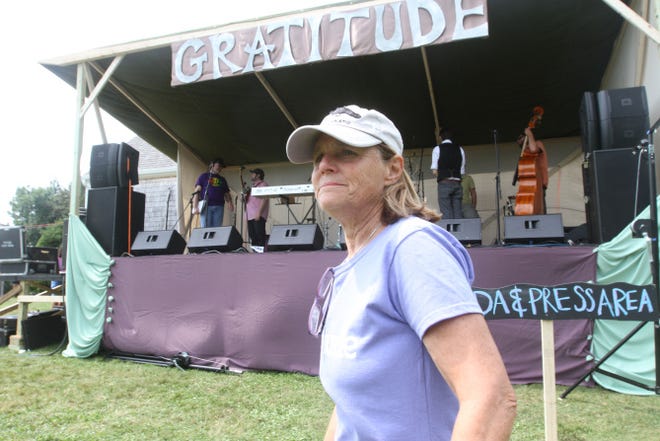 Galen Snow, whose family played host to the Little Compton Gratitude Festival, walks past one of the stages on Saturday. The family-friendly event featured musicians, food trucks, jewelers, artists, craft vendors and clothing designers.