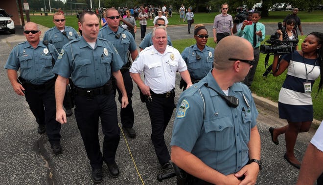 Police Chief Tom Jackson, right, of Ferguson, Missouri, and several of his 
officers leave a news conference Friday. Jackson took questions from the 
media after earlier identifying Darren Wilson as the officer who shot 
Michael Brown on Saturday night.AP PHOTO / ROBERT COHEN