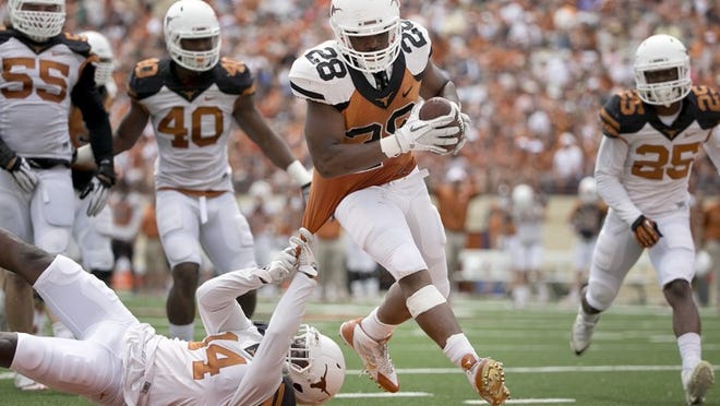 Malcolm Brown scores as Chevoski Collins tries to stop him at the annual Texas Football Orange-White Scrimmage at Royal Memorial Stadium on Saturday, April 19, 2014.
