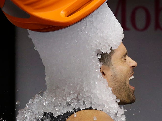 Tampa Bay Rays' David DeJesus gets a bucket of ice dumped on his head from video coordinator Chris Fernandez as part of the ALS Ice Bucket Challenge before a baseball game against the New York Yankees Sunday, Aug. 17, 2014, in St. Petersburg, Fla.