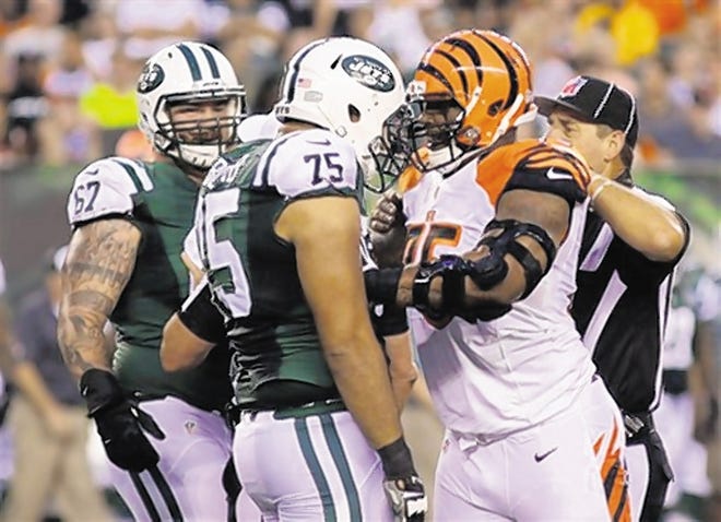 Officials separate Bengals DT Devon Still, right, and Jets OT Oday Aboushi, left, on Saturday night. Aboushi has been turning heads in camp with his aggressive play.
