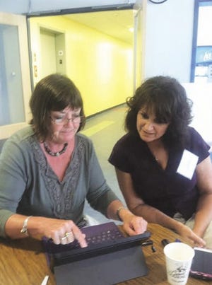 8/19/2014: Left to right. Marca Daley and Theresa Pacheco, both teachers at Sturgis Charter Public School, test Notability app at a workshop on using technology to assist students with learning disabilities on Aug. 18, 2014, at Sturgis. STaff photo by Cindy McCormick