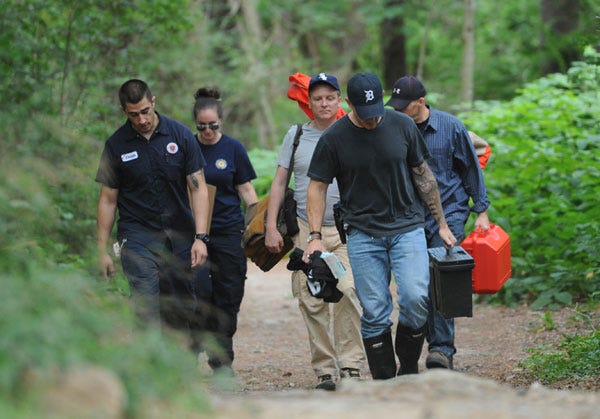 FALMOUTH -- 8/18/14 -- Officials from the state medical examiner’s office and state police leave Beebe Woods Conser­vation Area on Monday after­noon.