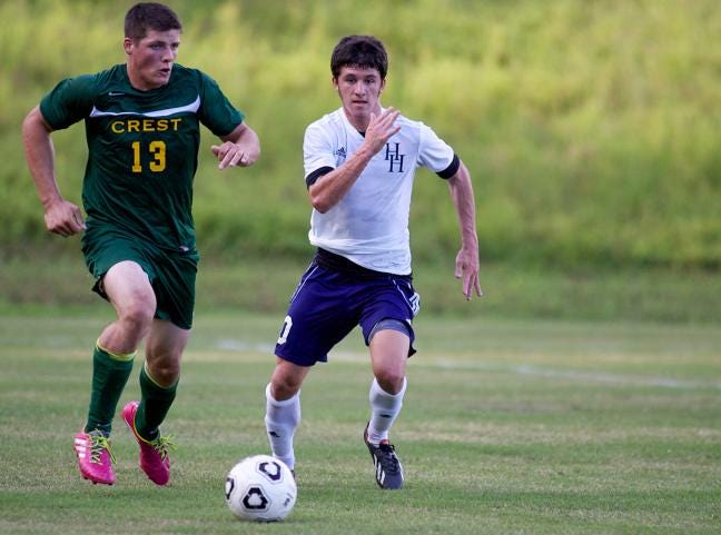 Crest’s Bradley Keller, left, and Huss’ Seth Jones go for the ball during Monday’s Gazette Cup opening match at Poston Park in Lowell. Jones scored twice in the victory.