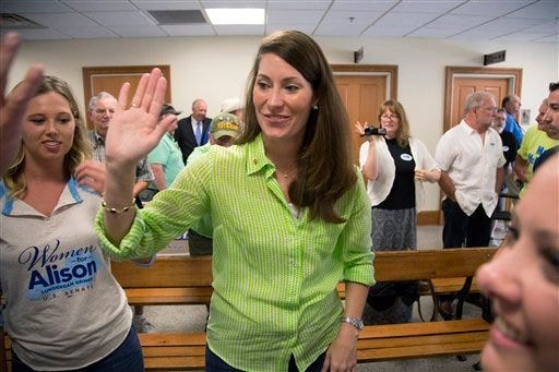 FILE - This July 30, 2014, file photo shows U.S. Senate candidate and Kentucky Secretary of State Alison Lundergan Grimes, as she greets a group of supporters during a campaign stop at the Bullitt County Courthouse in Shepherdsville, Ky. After 30 years in the Senate, now seeking six more, Minority Leader Mitch McConnell of Ky., isn't terribly popular at home. Fortunately for him, President Barack Obama is politically toxic, a fact the Republican leader is banking on to help him to victory in the fall against Democratic challenger Alison Lundergan Grimes. (AP Photo/David Stephenson, File)