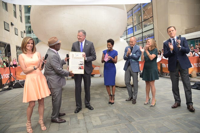 This image released by NBC shows New York Mayor Bill de Blasio, third from left, presenting co-host Al Roker, second left, with a proclamation declaring it Al Roker Appreciation Day during a broadcast of the "Today" show on Wednesday, Aug. 20, 2014, in New York. Joining the mayor and Roker are co-hosts Natalie Morales, left, Tamron Hall, center, Matt Lauer, third right, Meredith Vieira, and Willie Geist, right. Roker turned 60 on Wednesday.