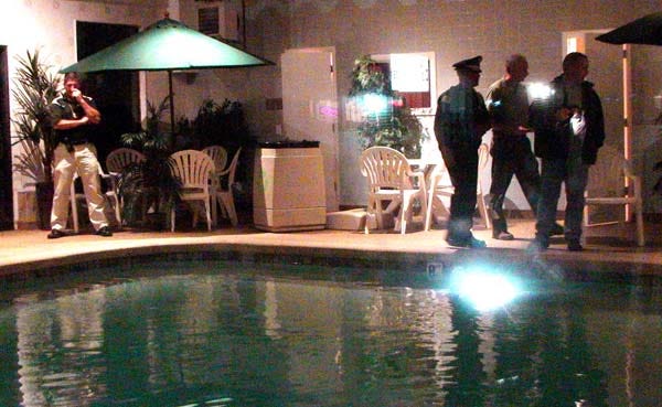 Police examine a West Yarmouth pool last night where two sisters nearly drown.