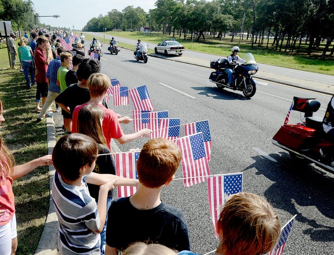 Students from Meigs Middle School line Eglin Parkway in Shalimar, Fla., on Thursday to honor the arrival of Army Staff Sgt. Sam Hairston's body. Hairston died while fighting last week in Afghanistan. Students from Shalimar Elementary lined the other side of the road as well as patrons from Burger King, firefighters from Ocean City Wright Fire Control District, ERA American Realty and the staff of Eglin Federal Credit Union.