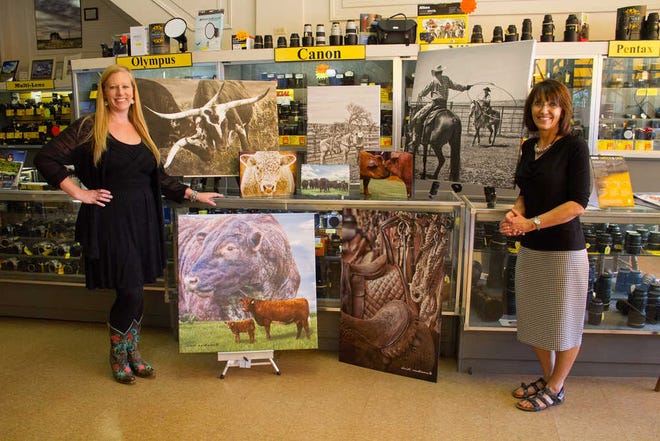 From left, Heidi Anderson and Sondra Harkness get ready for a First Friday Art Walk event on Sept. 5 at Wolfe's, 635 S. Kansas Ave. Anderson's photographs will be shown for the next five months after the event.