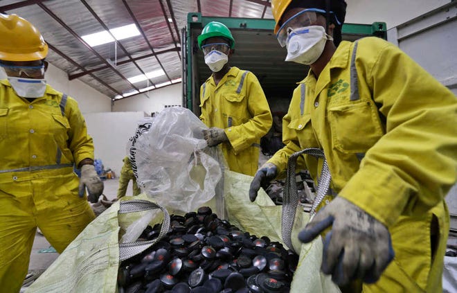 Workers sort through a sack of used inflight headphones from Kenya Airways to be recycled, at the East African Compliant Recycling facility in Machakos, near Nairobi, in Kenya. The amount of electronic waste generated globally last year is enough to fill 100 Empire State Buildings and represents more than 15 pounds for every living person.