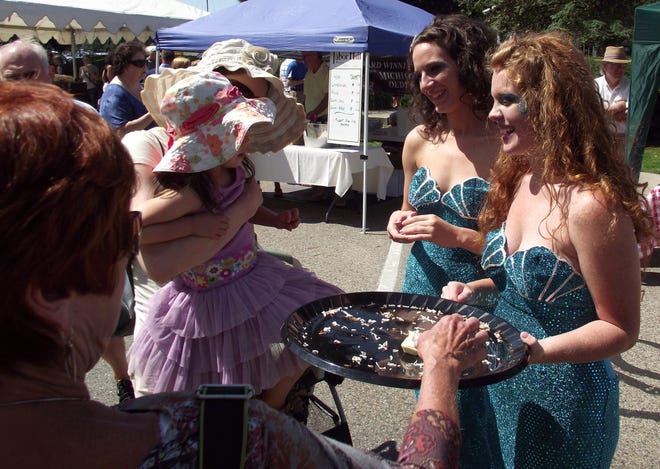 Whitney Williams, right, and Therese Herrick, left, of The Mermaid Bar and Grill, 340 Water St. in Saugatuck, offer coconut cream pie-flavored snacks to participants at the Taste of Saugatuck in this 2011 picture. Jim Hayden/Sentinel staff