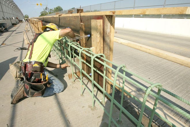 Russ Haupt, of Blackhorse Bridge and Construction, ties some reinforcing bar for a cement retaining wall separating hikers and bicyclists from vehicle traffic along the Tremont Avenue bridge. The wall is to act as a safety measure for all bridge users.